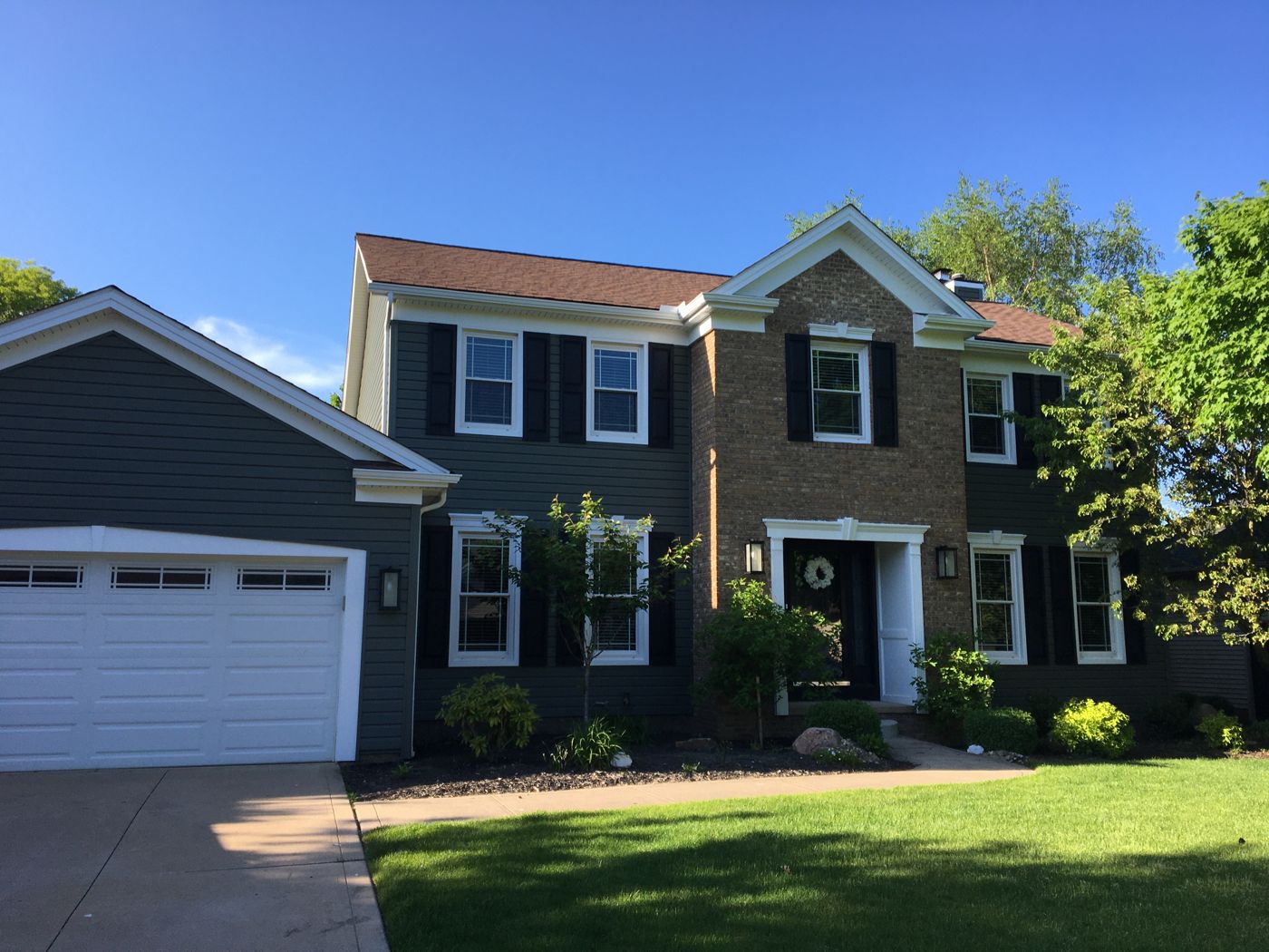 Finished dark home exterior with front entry door