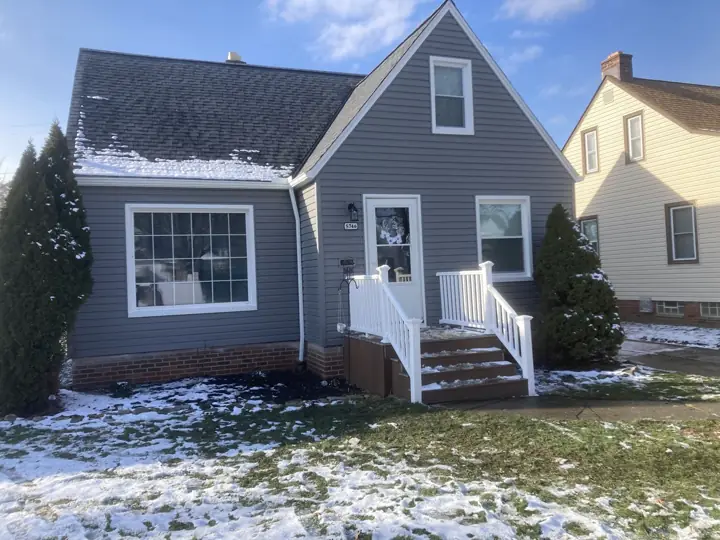 Completed gray siding exterior with white trim